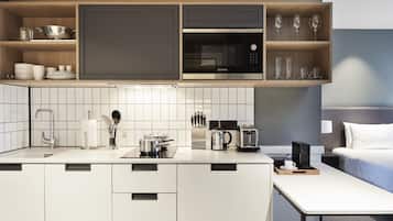 A modern kitchen with a microwave, toaster, and coffee maker, a sink, and a breakfast bar.