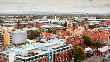 A cityscape with a mix of modern and historic buildings, including a prominent church with a tall steeple.