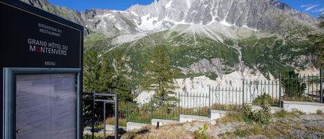 Une enseigne pour le Grand Hôtel du Montenvers, avec un paysage montagneux en arrière-plan.