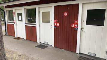 Una fila de baños portátiles blancos y rojos con señalización clara.