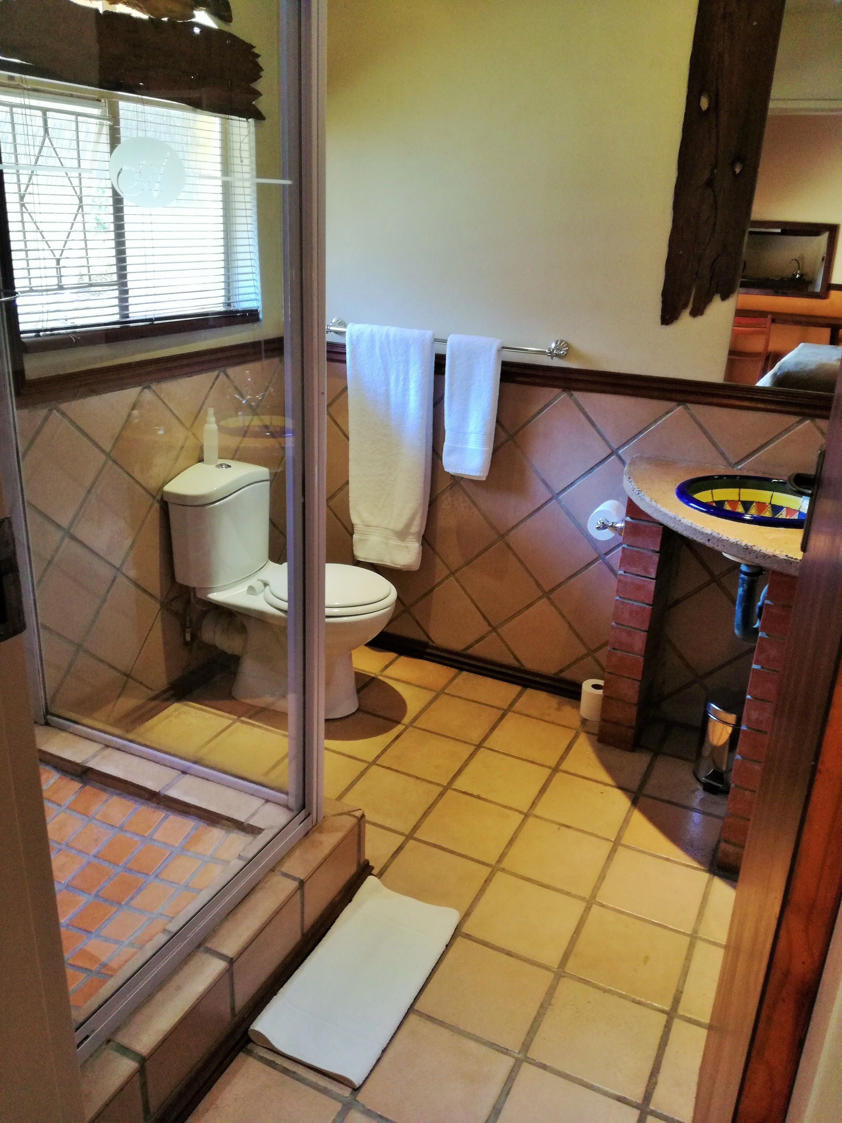 Un baño con inodoro, lavamanos y ventana.