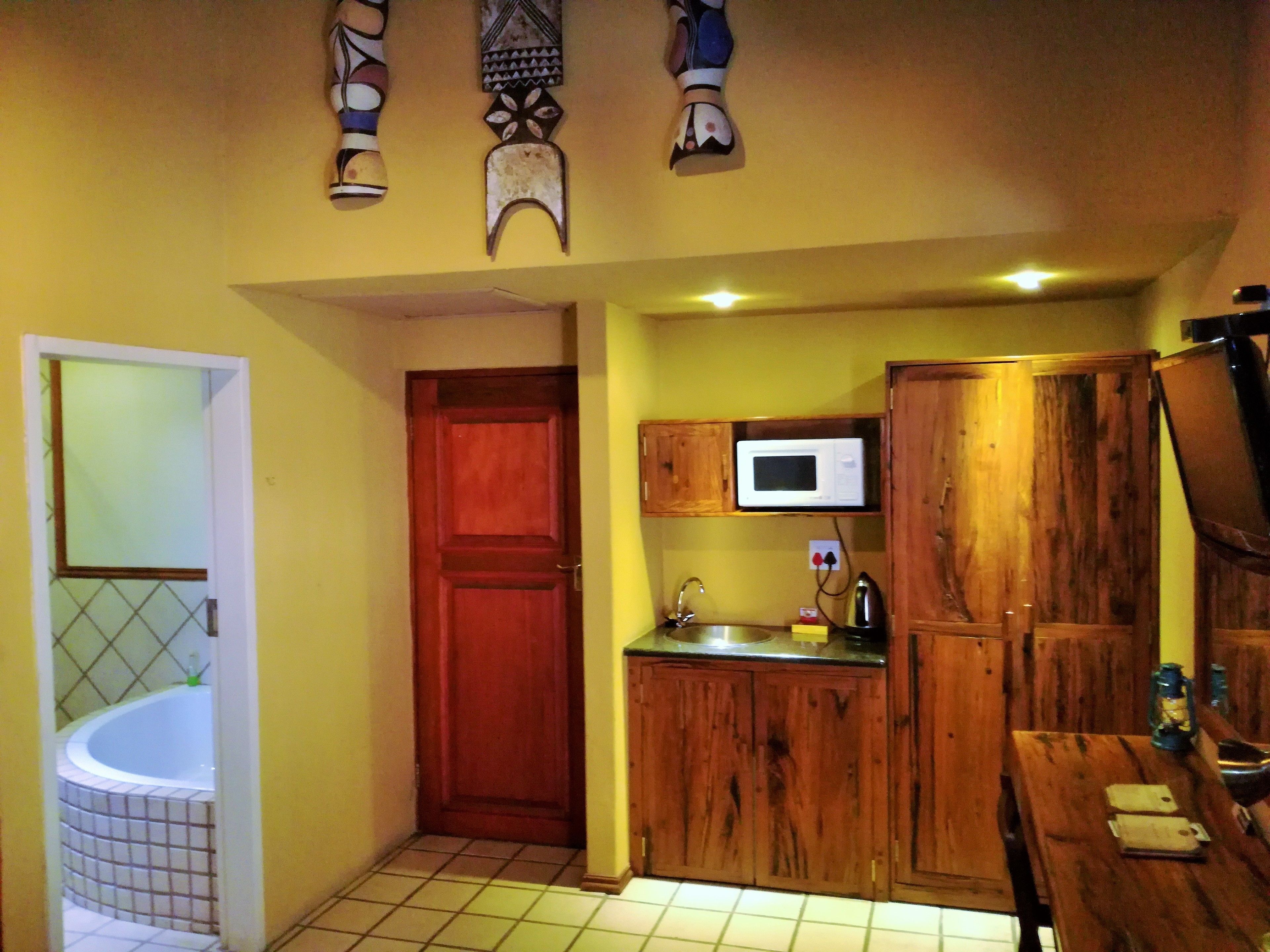 A compact kitchen with wooden cabinets, a microwave, and a sink.