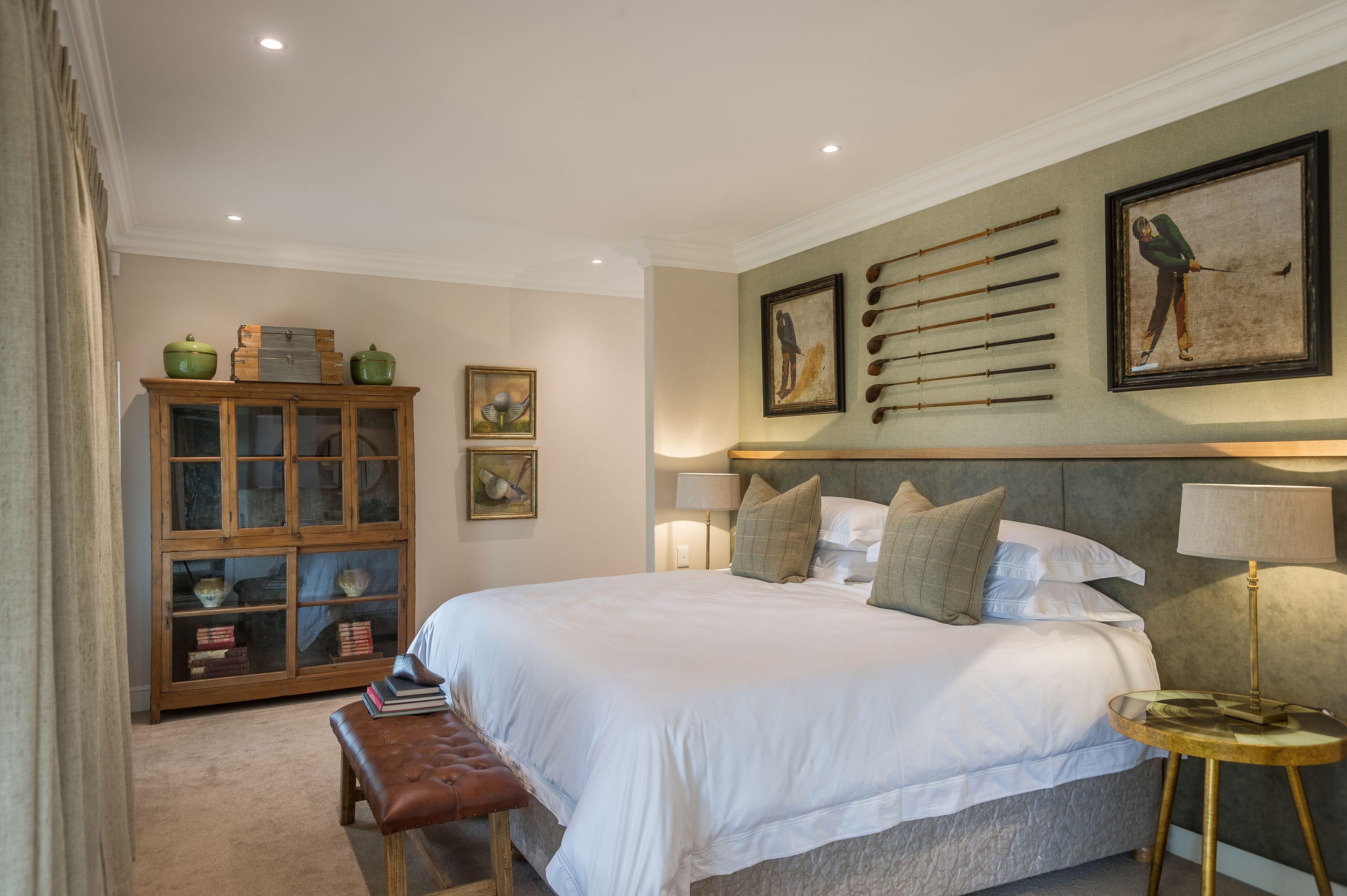 Une chambre à coucher avec un grand lit, une armoire en bois et une table de chevet avec une lampe.