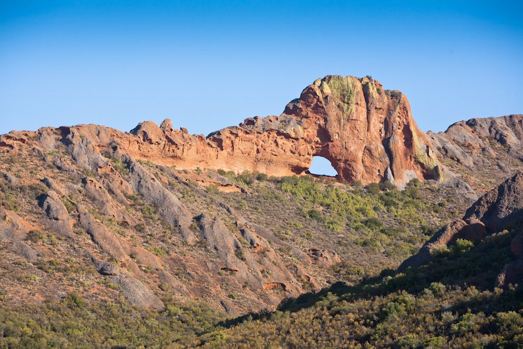 A rugged landscape with a prominent rock arch formation.