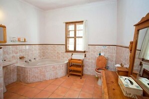 A bathroom with a bathtub, a toilet, a sink, and a window.