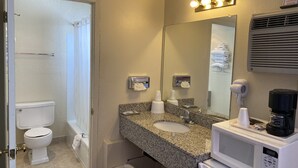 A bathroom with a toilet, sink, mirror, towel rack, and a hairdryer. - Econo Lodge Las Vegas NM (Las Vegas)