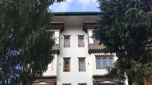 Un edificio de varios pisos con elementos arquitectónicos tradicionales, como marcos de ventanas ornamentados y diseños decorativos en la fachada.