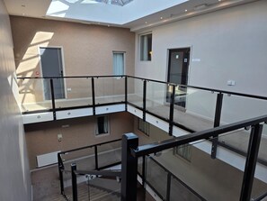 A multi-level interior with glass railings, a staircase, and a skylight. - Quarterz (Chester)