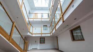 A spacious atrium with a high ceiling, skylights, and a central staircase. - Quarterz (Chester)