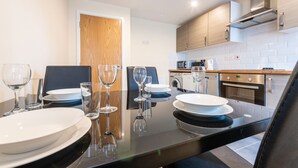 A modern kitchen with a dining area, equipped with a stove, microwave, and oven. - Quarterz (Chester)