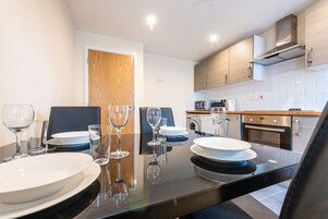 A modern kitchen with a dining area, equipped with a stove, microwave, and oven.