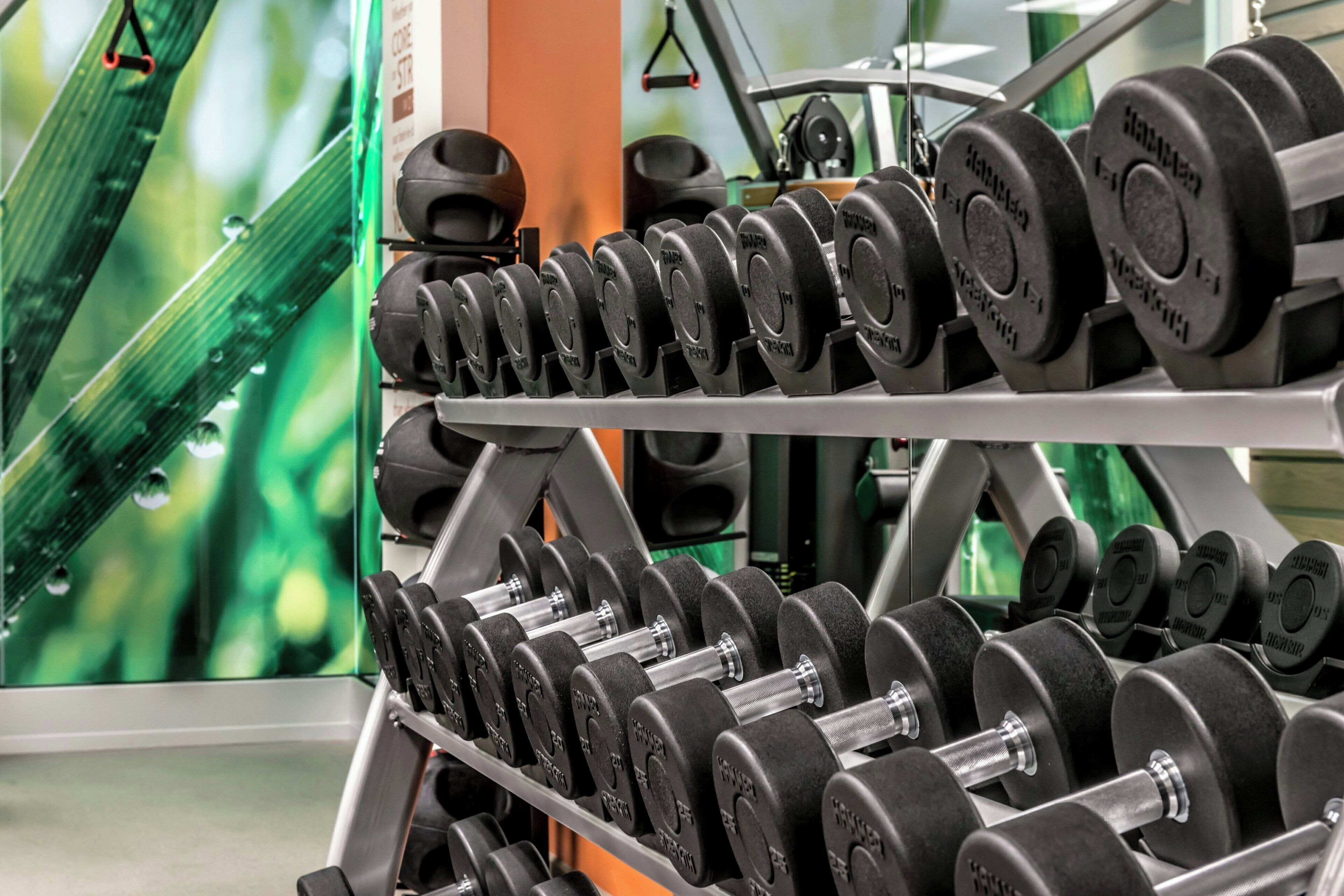 A weightlifting rack with multiple sets of dumbbells.