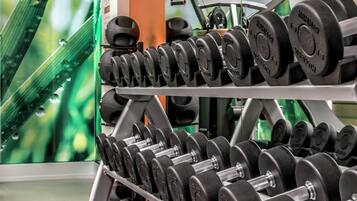 A weightlifting rack with multiple sets of dumbbells.