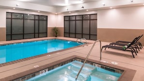 An indoor swimming pool with clear water, a diving board, and lounge chairs along the side. - Courtyard by Marriott Eugene Downtown (Eugene)