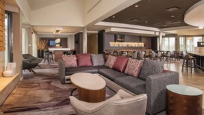 A modern hotel lobby with a sectional sofa, bar area, and dining space. - Courtyard by Marriott Eugene Downtown (Eugene)