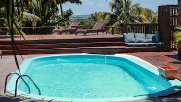 Una piscina al aire libre, tumbonas