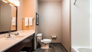 A bathroom with a white sink, mirror, toilet, and shower. - False River Hotel  (New Roads)