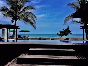 Una piscina infinita con vistas a la playa y al océano.