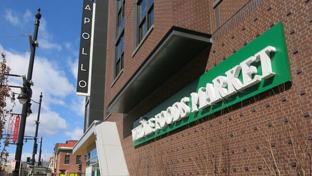 A brick building with a sign for 'APOLLO' and 'Wholefoods Market'. - Capitol Hill 2 Bedroom, 6ppl, Patio, Free Parking, near Capitol, Eastern Market (Washington)