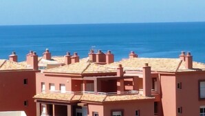 Un edificio frente al mar con varios chimeneas y balcones.