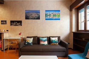 Relax in a cozy living area with a comfortable sofa, decorative pillows, and a wooden chair.