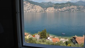 A view from a window overlooking a lake with mountains in the background.