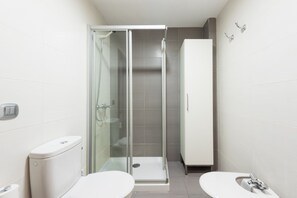 Een bad/douchecombinatie, een haardroger, een bidet, handdoeken