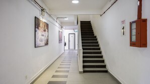 Käytävä, jossa on portaikko, joka johtaa hissiin.