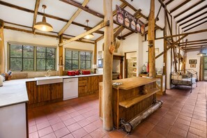 Una cocina rústica con vigas de madera, un ventanal grande y un letrero que dice "The Cupcake Bakery".