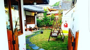 Ein traditioneller japanischer Garten mit einem steinbesetzten Weg, der zu einer Holztür führt.