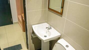 Une salle de bain avec des toilettes, un lavabo et un miroir.