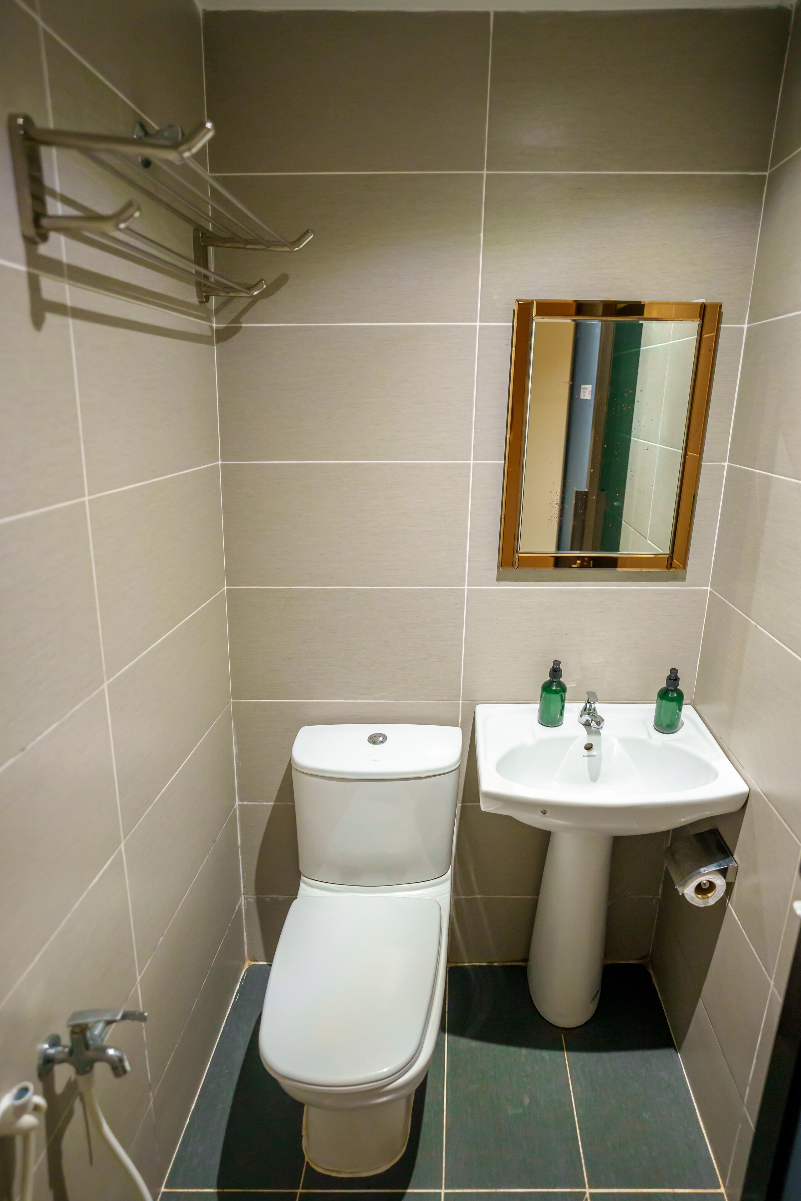 A small bathroom with a toilet, sink, and mirror.
