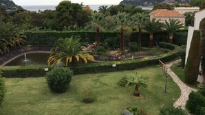 A well-maintained garden with a pond, palm trees, and a view of the sea. - Residence of the Guardian Angel, Beachfront apartment, Villefranche / Mer (Villefranche-sur-Mer)