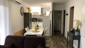 Una cucina moderna con zona pranzo, un divano e un piccolo tavolo con un vaso.
