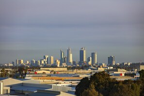 Une vue panoramique d’une ville, avec de nombreux immeubles de grande hauteur, dont un bâtiment remarquable qui se distingue par son motif en forme de chevron.