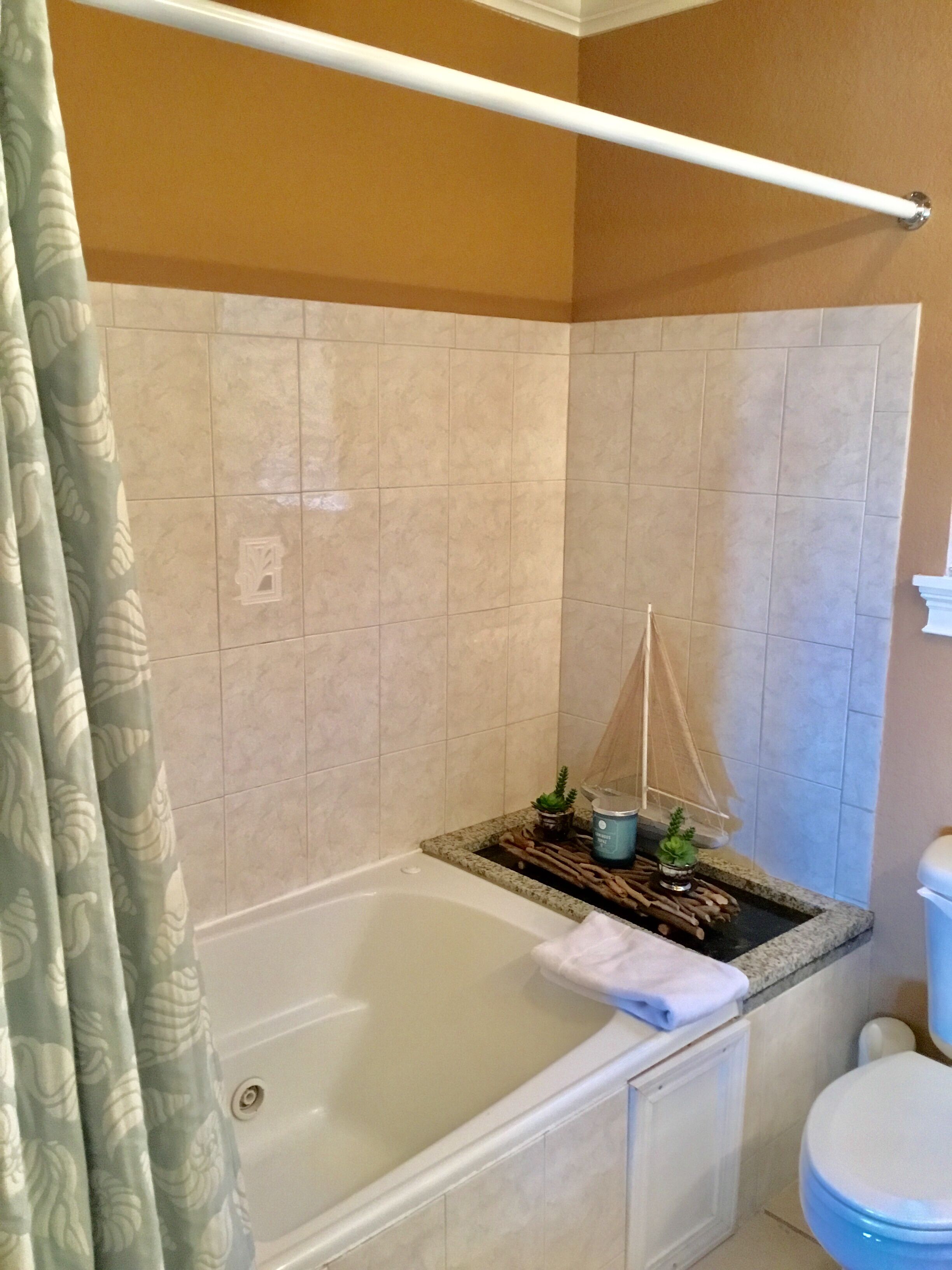 Un bagno con vasca, servizi igienici e tenda da doccia.