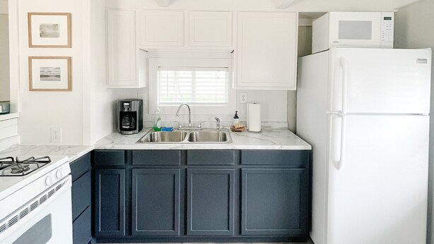 A kitchen with white cabinets, a white refrigerator, a stove, and a sink. - Lake McConaughy Cabin within walking distance to beach!  (Lewellen)