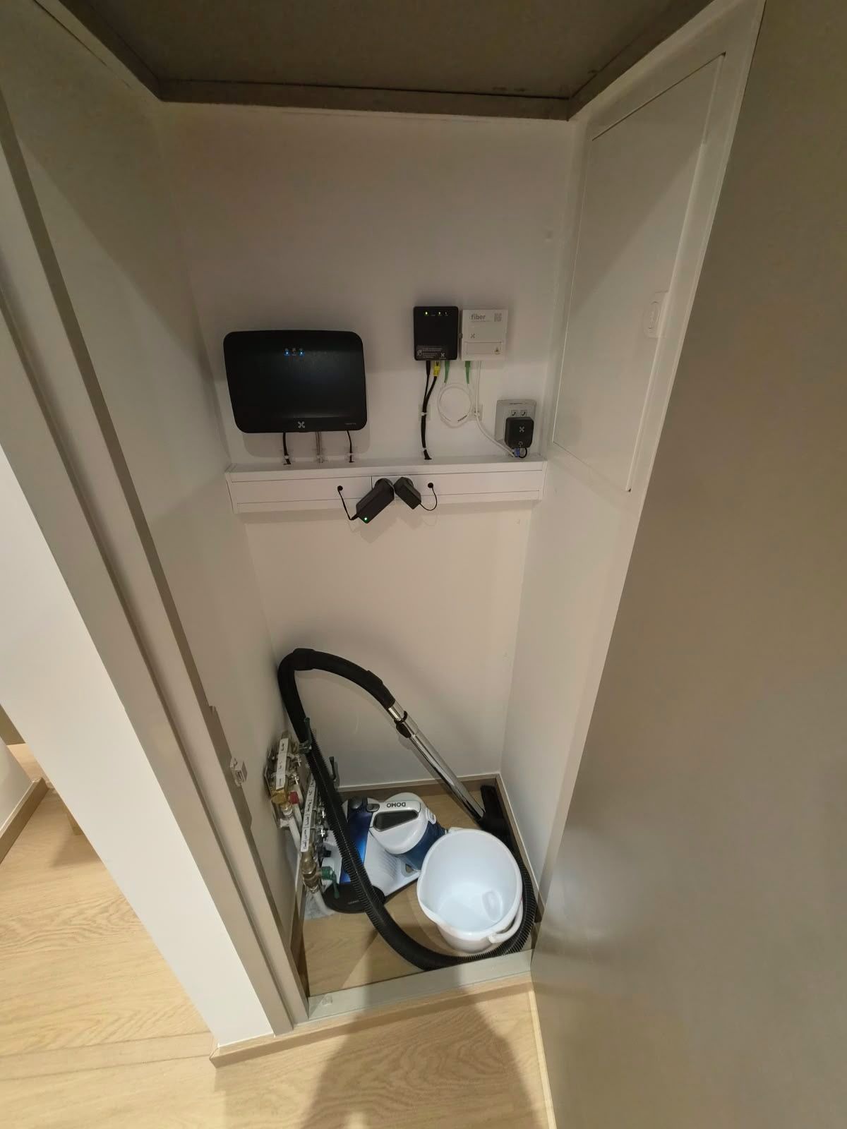 Un bagno compatto con il water, un aspirapolvere portatile e una ciabatta multipresa.
