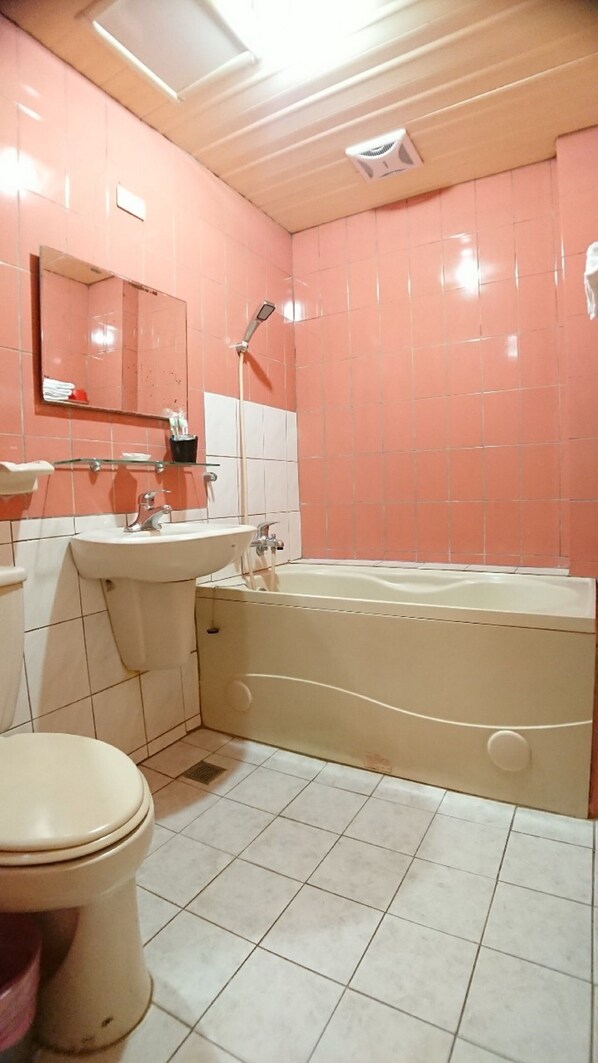 A bathroom with a toilet, sink, and bathtub. - YesHotel (Chiayi City)