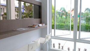 Een moderne kamer met een groot raam, een bureau en een stoel.