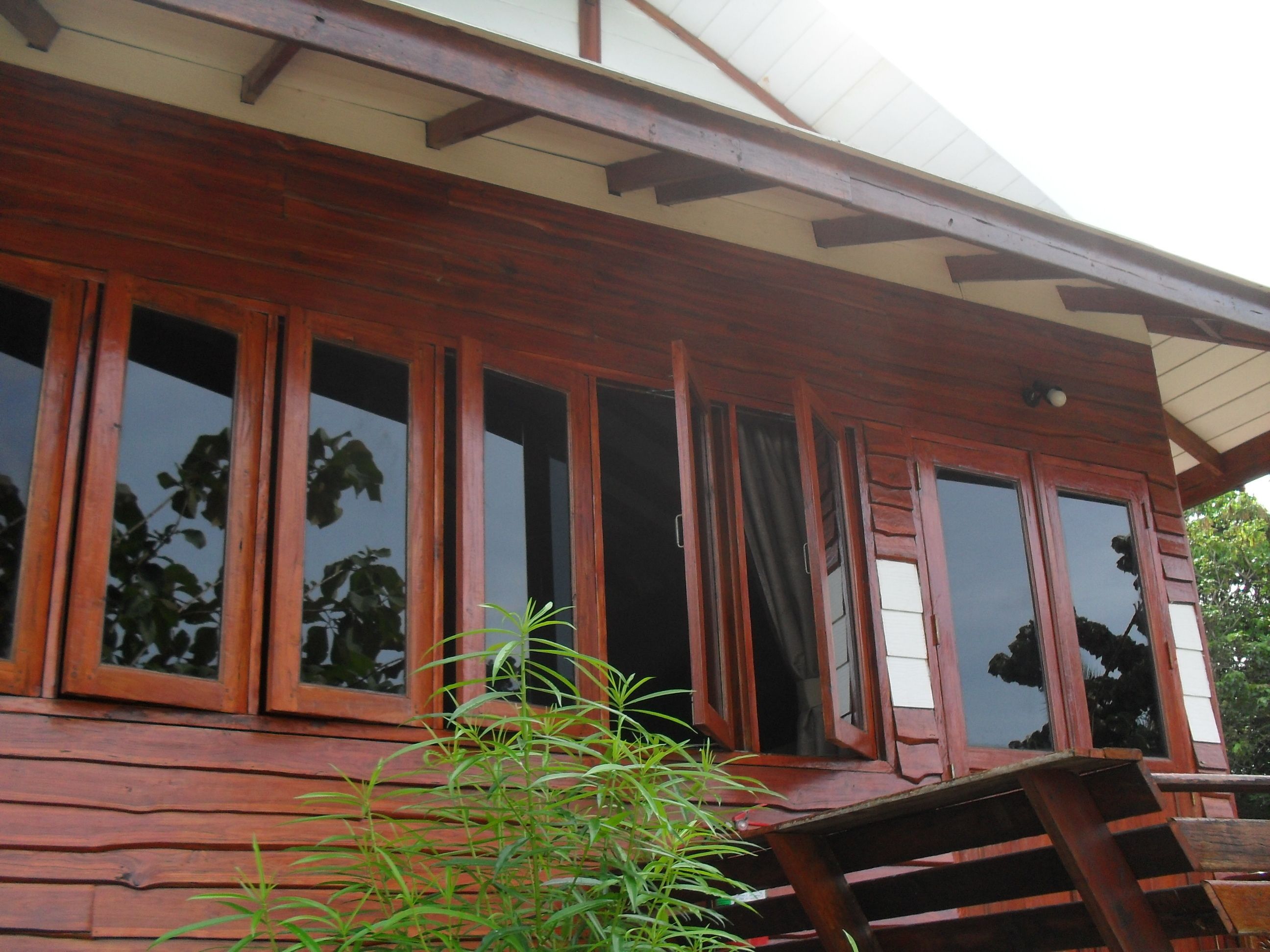Eine Holzhütte mit großen Fenstern und einer Veranda.