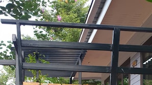 Een meerlaags houten constructie met een tuin ervoor.