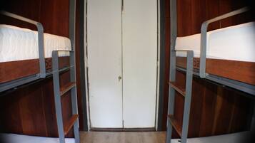 A bunk bed room with a wooden door and metal railings.