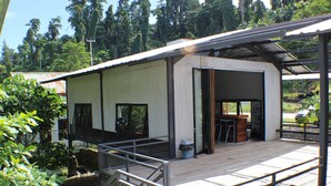 Edifici modern amb una zona exterior coberta, una escala i un cubell de brossa.