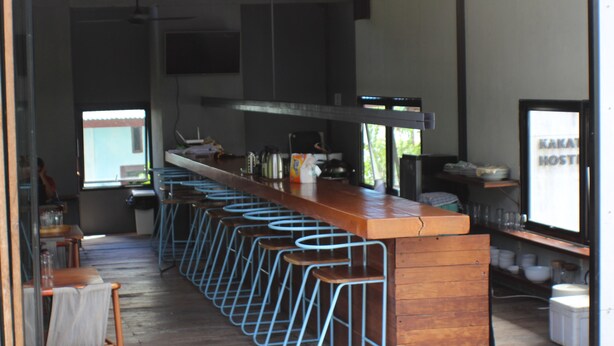 Zona de bar amb tamborets, una barra i vistes cap a l'exterior.