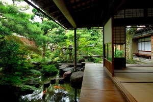 A traditional Japanese garden with a koi pond, wooden walkways, and lush greenery.