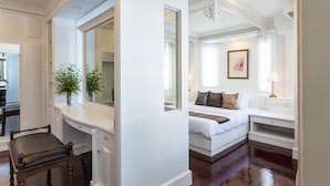 A bedroom with a bed, bedside table, lamp, and a large mirror. - The Lek Aree (Bangkok)