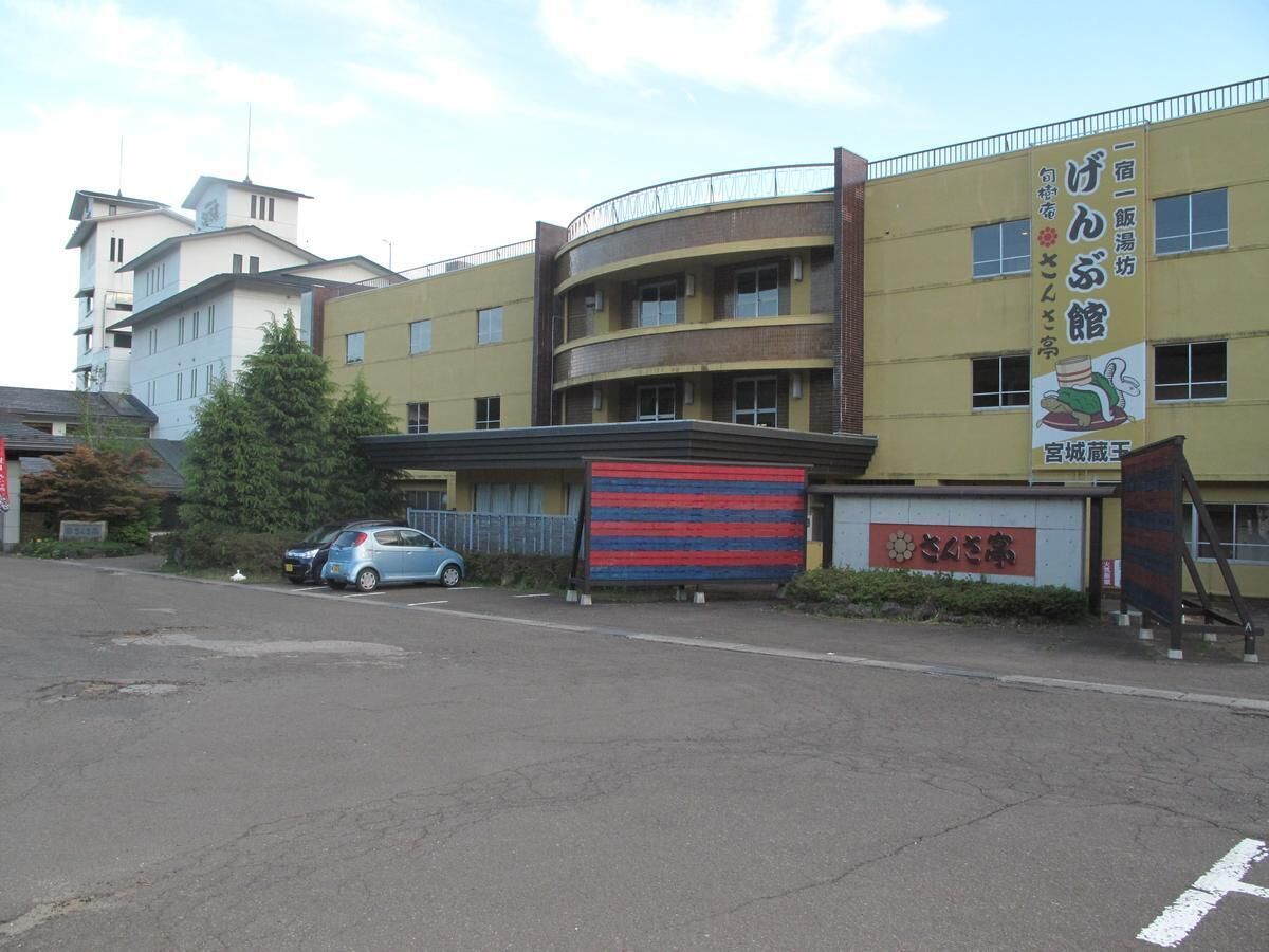 Monikerroksinen rakennus, jonka edessä on parkkipaikka.