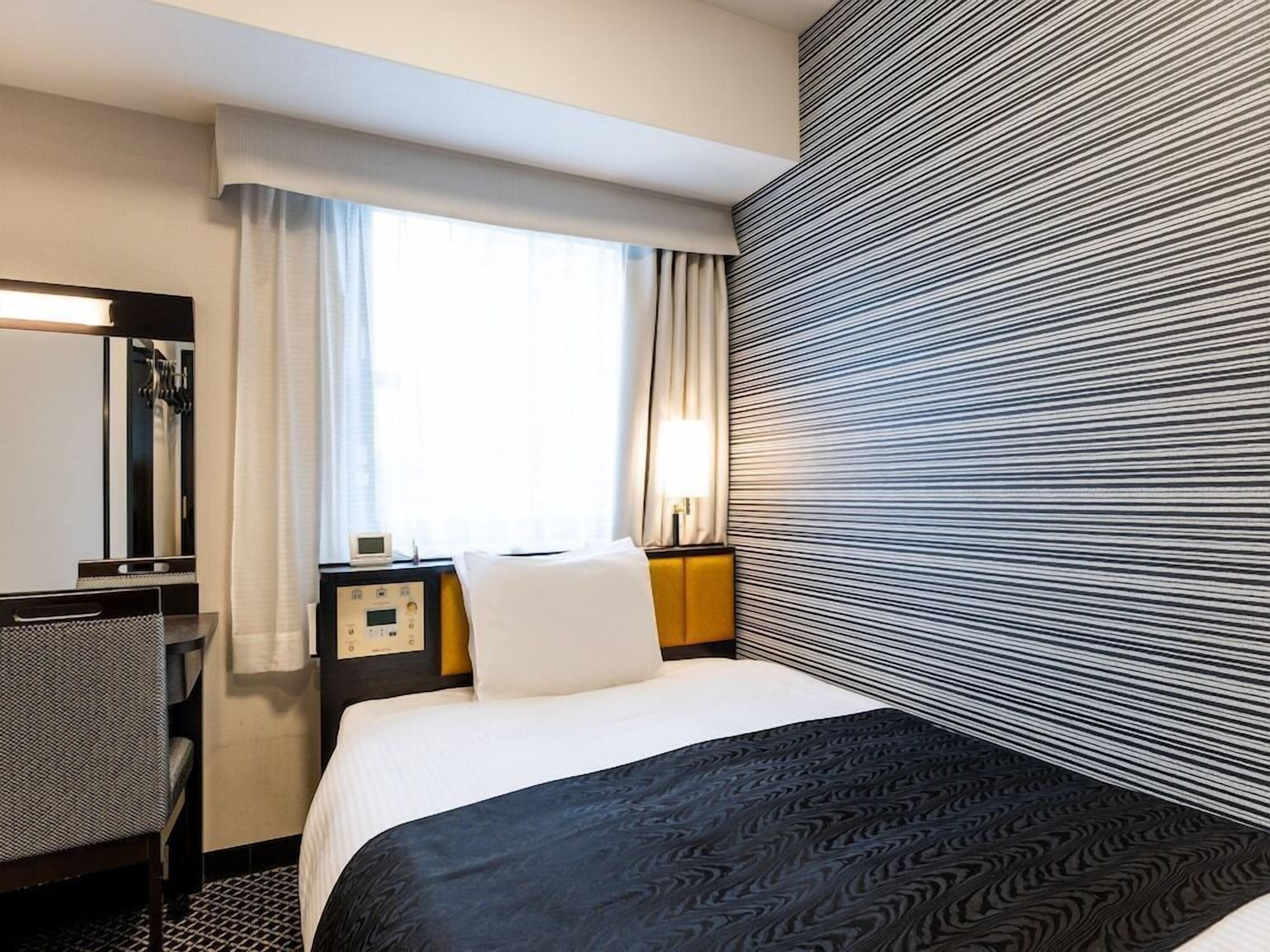 Luxe beddengoed, donzen dekbedden, een bureau, verduisterende gordijnen