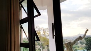 An open balcony with a view of a tree and distant landscape. - Chinyonga Guesthouse (Blantyre)